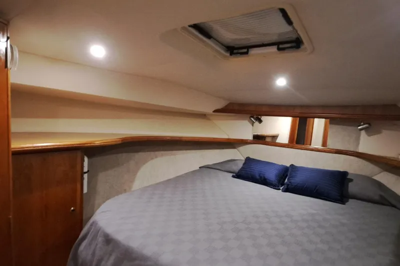 Slide: The Image of Interior cabin of 2000 Silverton 42 Convertible yacht with cozy bed and lighting. - 16