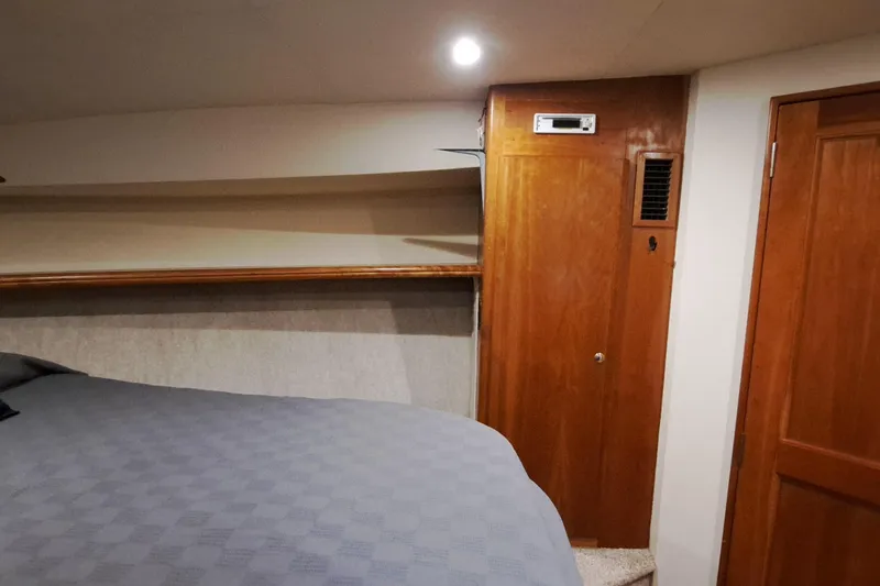 Slide: The Image of Interior cabin of 2000 Silverton 42 Convertible yacht with wooden accents and cozy bed. - 17