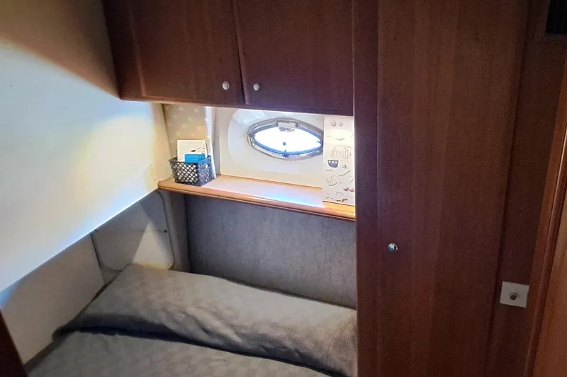 Slide: The Image of Cozy cabin interior of 2000 Silverton 42 Convertible yacht with porthole and wooden cabinetry. - 18