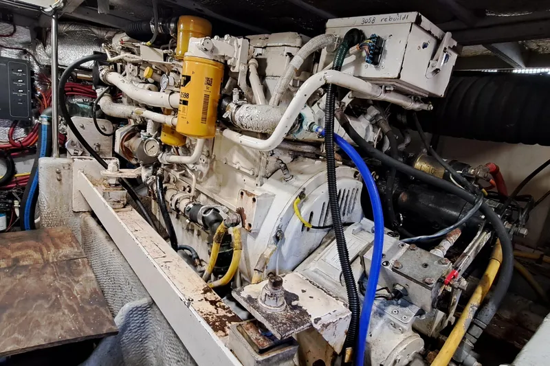 Slide: The Image of Engine room of a 2000 Silverton 42 Convertible boat, showcasing complex machinery and wiring. - 22