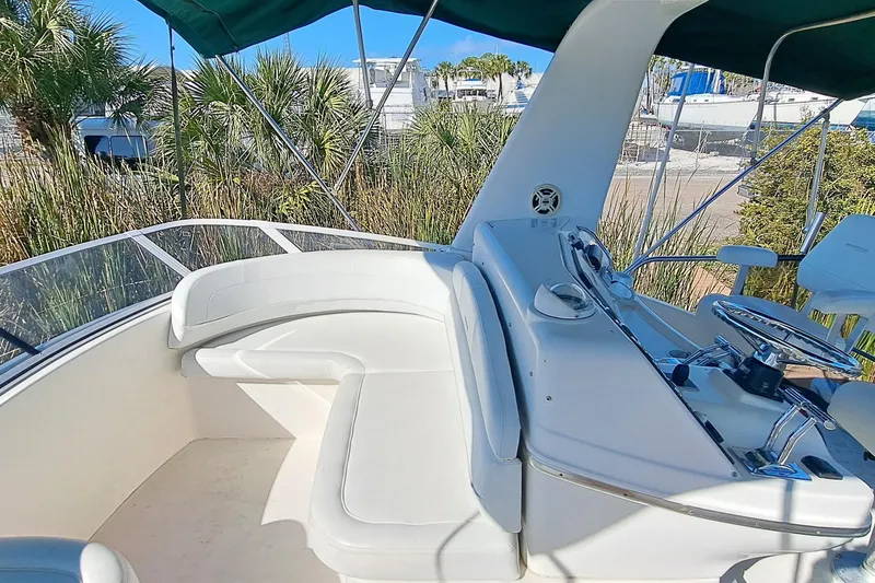 Slide: The Image of 2000 Silverton 42 Convertible yacht helm with white seating and green canopy. - 8
