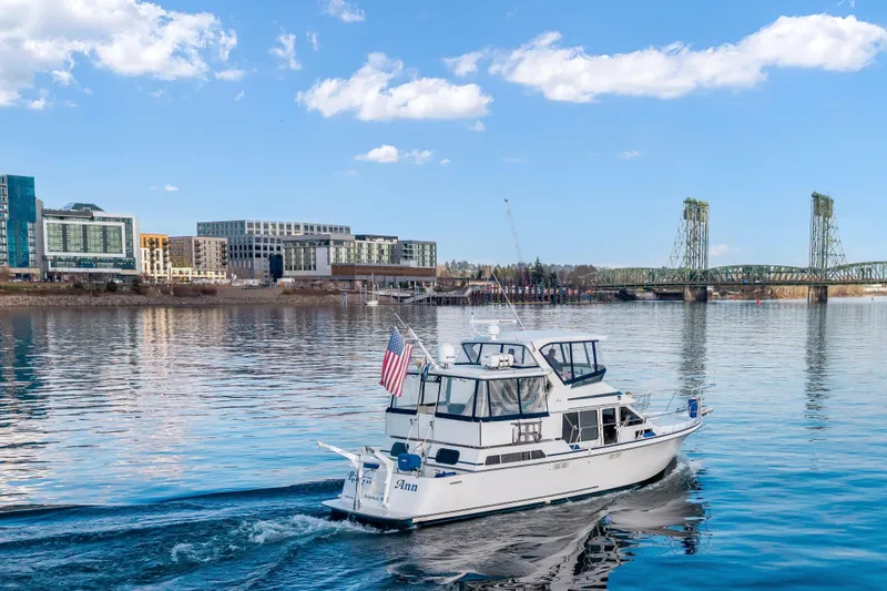 Slide: The Image of 1994 Tollycraft 45 Cockpit Motor Yacht cruising near city waterfront and bridge. - 10
