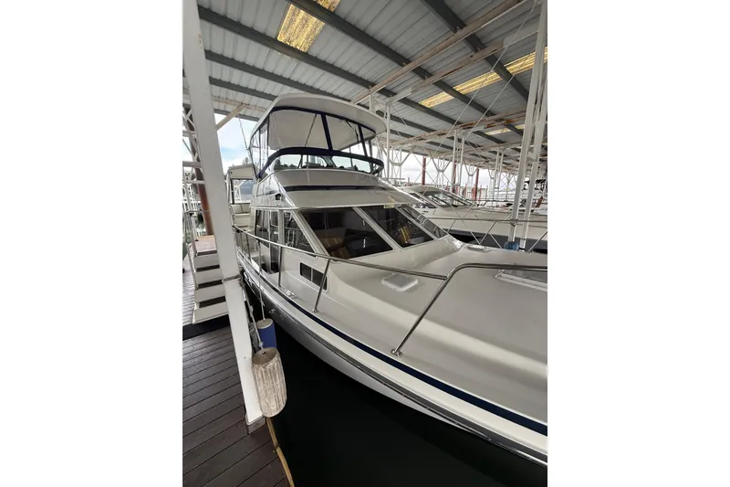 Slide: The Image of 1994 Tollycraft 45 Cockpit Motor Yacht docked in a covered marina. - 17