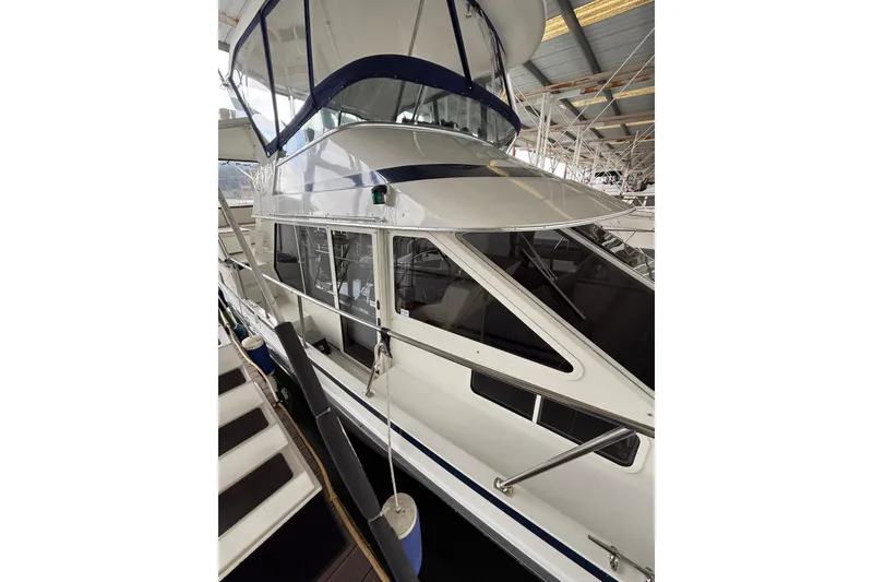 Slide: The Image of 1994 Tollycraft 45 Cockpit Motor Yacht in a covered marina, showcasing sleek design and spacious cockpit. - 18