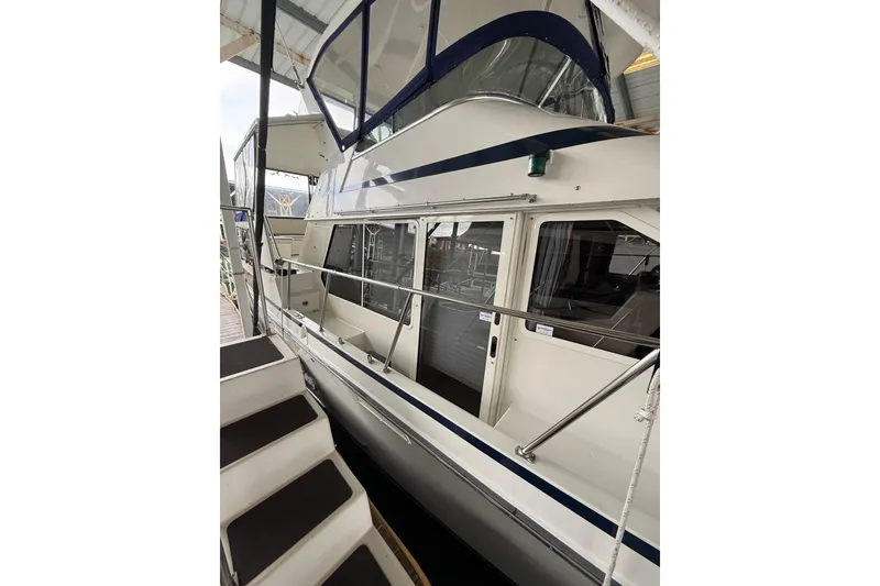 Slide: The Image of 1994 Tollycraft 45 Cockpit Motor Yacht docked, showcasing sleek design and spacious deck. - 19
