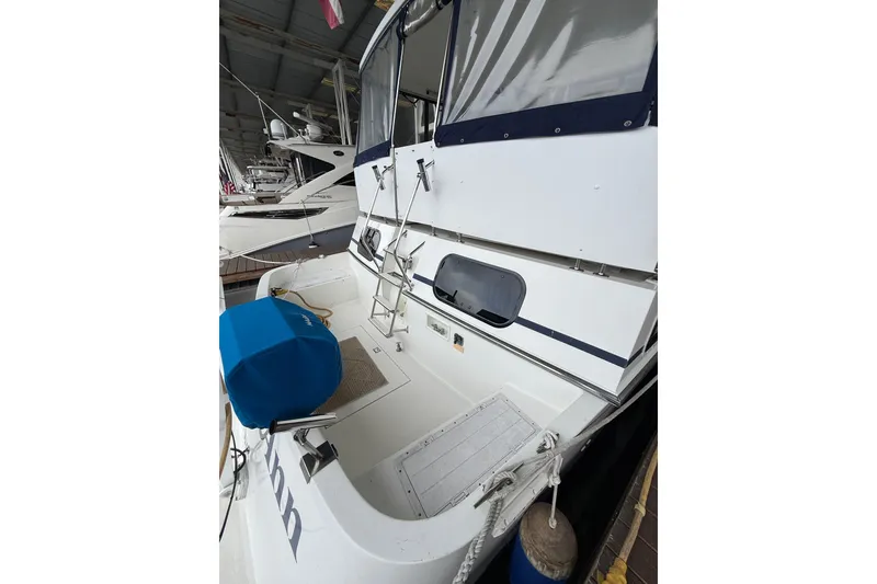 Slide: The Image of 1994 Tollycraft 45 Cockpit Motor Yacht, docked, featuring spacious cockpit and covered seating area. - 21