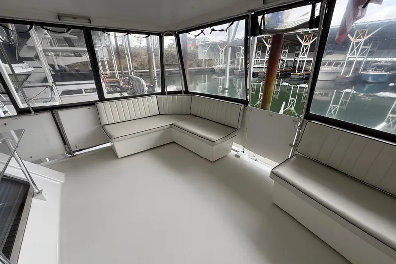 Slide: The Image of 1994 Tollycraft 45 Cockpit Motor Yacht interior with white seating and marina view. - 27