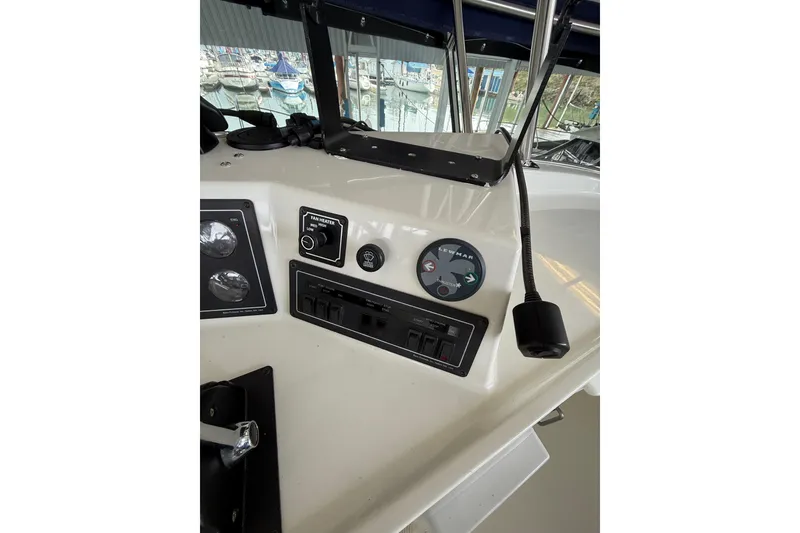 Slide: The Image of 1994 Tollycraft 45 Cockpit Motor Yacht helm controls with gauges and switches. - 33