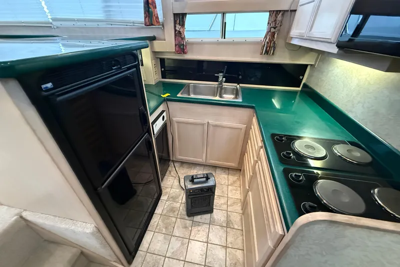 Slide: The Image of 1994 Tollycraft 45 Cockpit Motor Yacht kitchen with green countertops and modern appliances. - 37