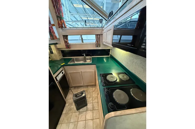Slide: The Image of 1994 Tollycraft 45 Cockpit Motor Yacht kitchen with green countertops and modern appliances. - 38