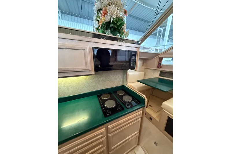 Slide: The Image of 1994 Tollycraft 45 Cockpit Motor Yacht kitchen with stove, microwave, and dining area. - 42