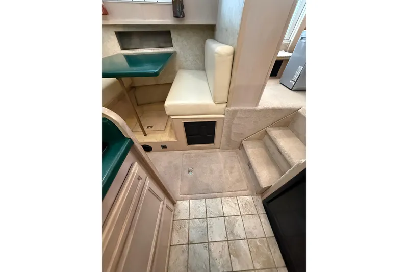 Slide: The Image of 1994 Tollycraft 45 Cockpit Motor Yacht interior with seating, stairs, and tiled flooring. - 43