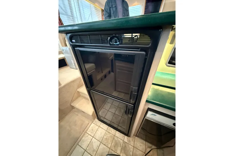 Slide: The Image of 1994 Tollycraft 45 Cockpit Motor Yacht interior with compact black refrigerator. - 47