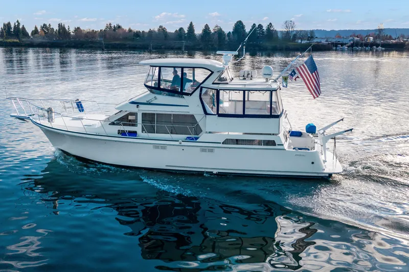 Slide: The Image of 1994 Tollycraft 45 Cockpit Motor Yacht cruising on calm waters with American flag. - 5