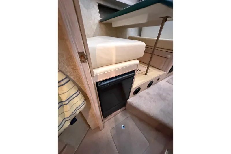 Slide: The Image of 1994 Tollycraft 45 Cockpit Motor Yacht interior with compact fridge and seating area. - 52