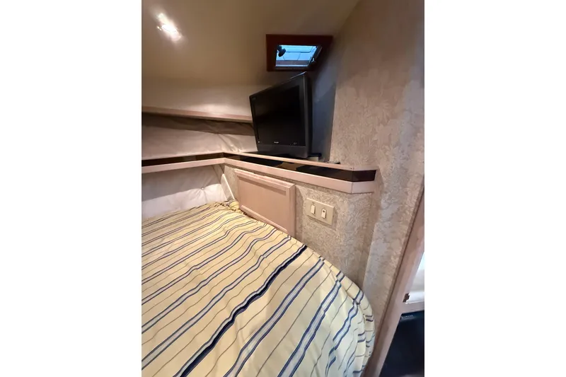 Slide: The Image of 1994 Tollycraft 45 Cockpit Motor Yacht bedroom with striped bedding and TV. - 53