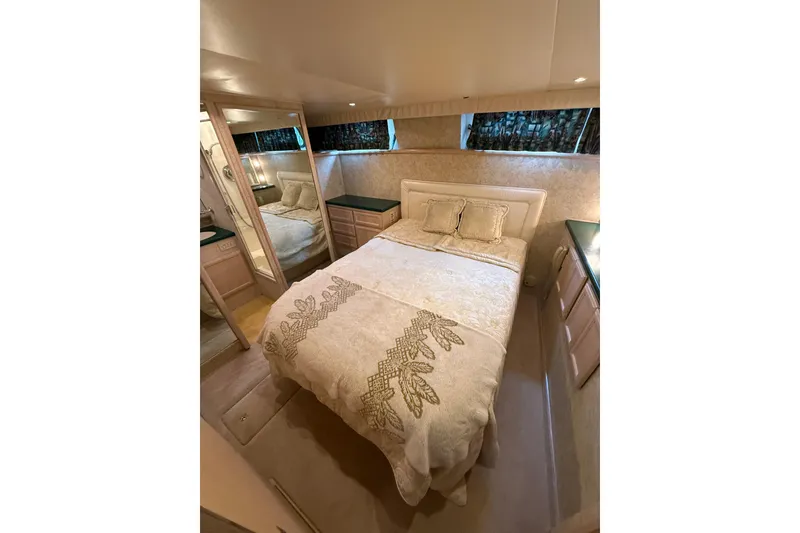 Slide: The Image of Luxurious bedroom in 1994 Tollycraft 45 Cockpit Motor Yacht with elegant bedding and mirrored closet. - 58