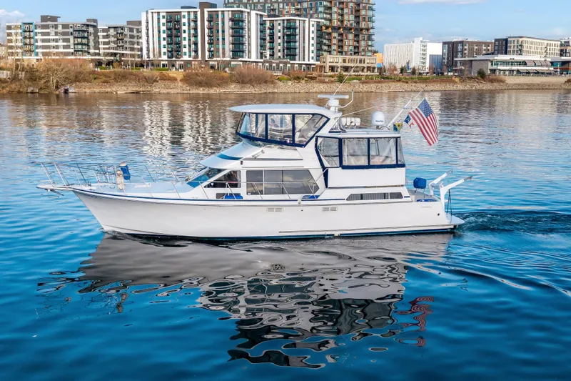 Slide: The Image of 1994 Tollycraft 45 Cockpit Motor Yacht cruising on calm waters near urban skyline. - 6
