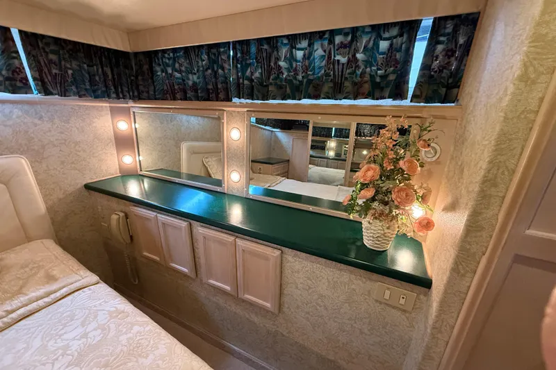 Slide: The Image of 1994 Tollycraft 45 Cockpit Motor Yacht interior with vanity, floral arrangement, and soft lighting. - 60
