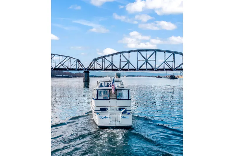 Slide: The Image of 1994 Tollycraft 45 Cockpit Motor Yacht cruising under a bridge on a sunny day. - 7