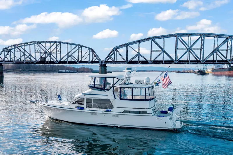 Slide: The Image of 1994 Tollycraft 45 Cockpit Motor Yacht cruising under a steel bridge on a sunny day. - 8