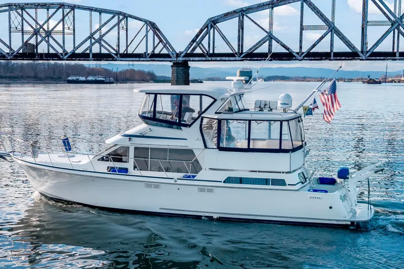 Slide: The Image of 1994 Tollycraft 45 Cockpit Motor Yacht cruising under a bridge on a calm river. - 9