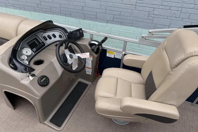 Slide: The Image of 2020 Sun Tracker Party Barge 20 DLX helm with beige captain's chair and control panel. - 7