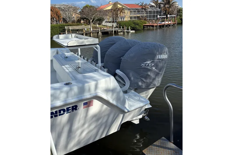 Slide: The Image of 2024 Contender 39 ST boat with triple Yamaha engines docked in marina. - 19