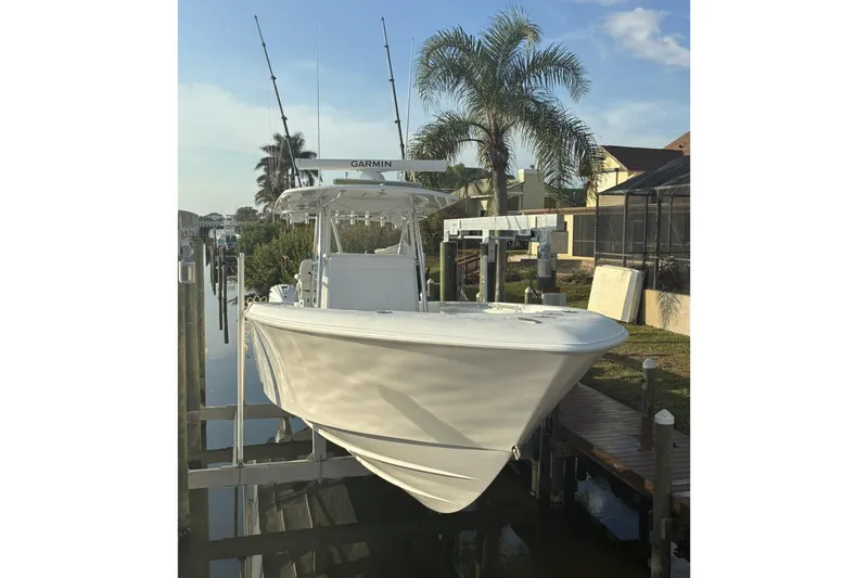 Slide: The Image of 2024 Contender 39 ST boat on trailer, parked under a clear blue sky. - 4
