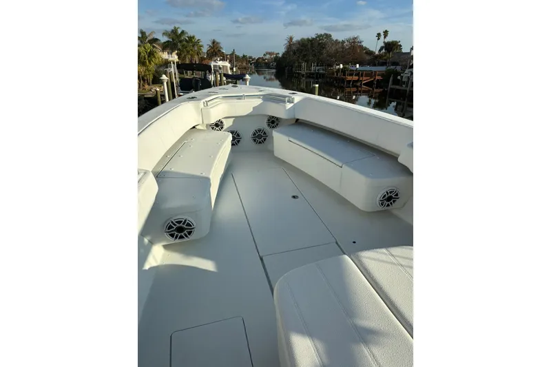 Slide: The Image of 2024 Contender 39 ST boat with luxurious white seating and scenic waterfront view. - 7