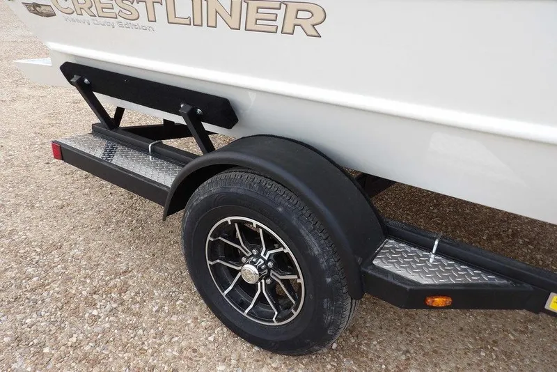 Slide: The Image of Trailer of 2026 Crestliner 1870 Retriever FCC boat with black wheel and diamond plate step. - 40