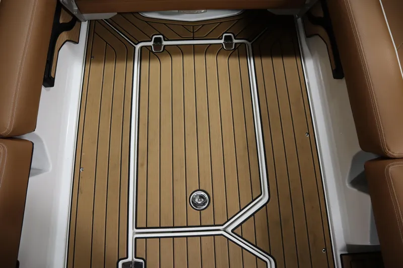 Slide: The Image of 2023 Nautique Super Air Nautique G23 interior with teak-style flooring and brown seating. - 20
