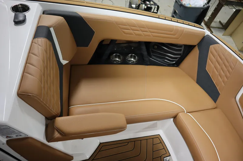 Slide: The Image of 2023 Nautique Super Air Nautique G23 interior with tan leather seating and cup holders. - 5