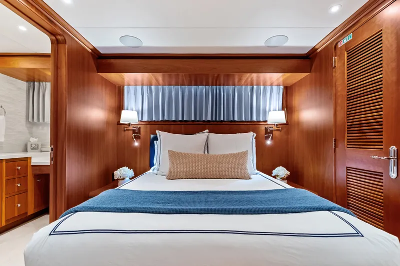 Slide: The Image of Luxurious bedroom interior on 1998 Burger Raised Pilothouse yacht, featuring elegant wood paneling. - 24