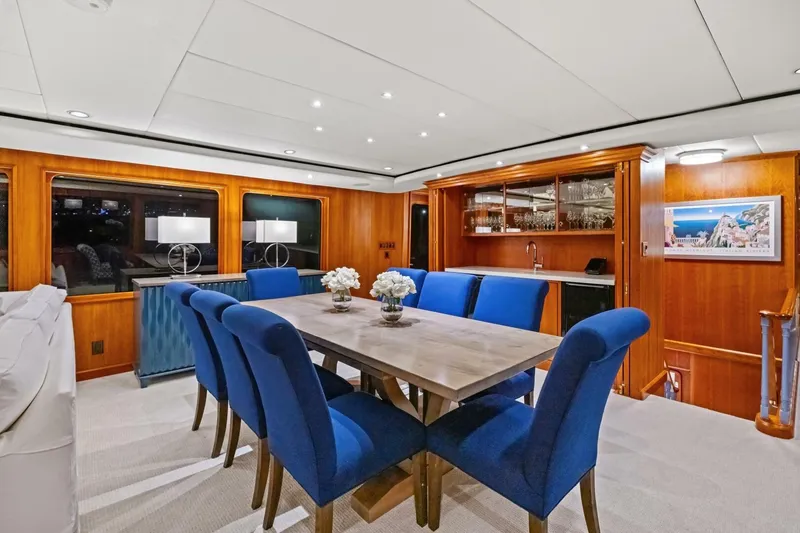 Slide: The Image of Luxurious dining area on 1998 Burger Raised Pilothouse yacht with blue chairs and wooden accents. - 4