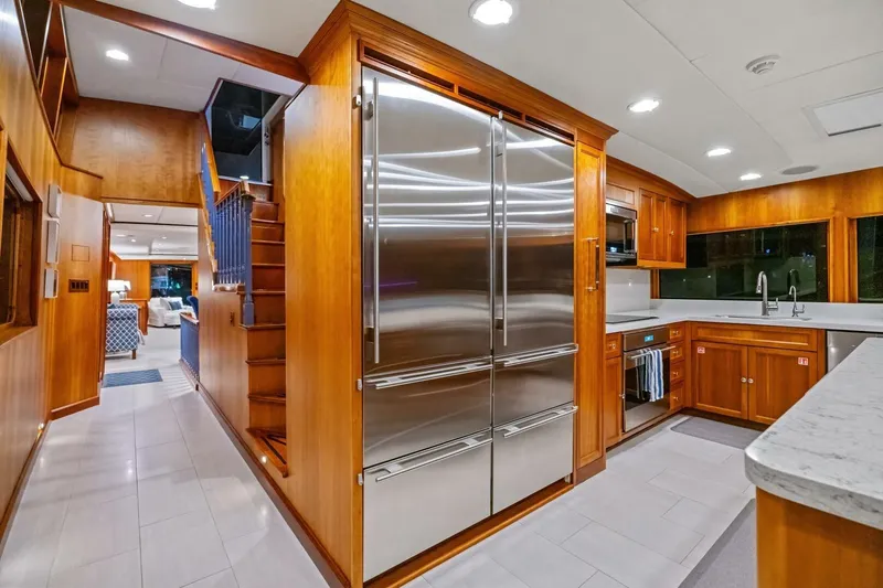 Slide: The Image of Luxurious 1998 Burger Raised Pilothouse yacht kitchen with stainless steel appliances and wooden cabinetry. - 9