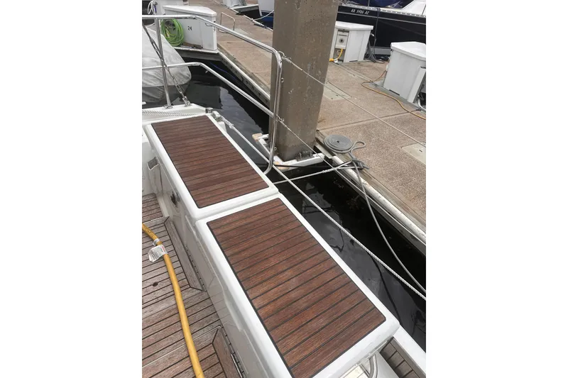 Slide: The Image of Beneteau Oceanis 46.1 (2025) docked, featuring sleek wooden deck details. - 10