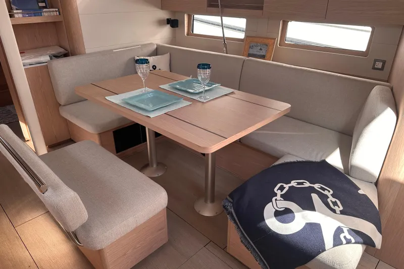 Slide: The Image of Interior of 2025 Beneteau Oceanis 46.1 yacht with cozy dining area and elegant table setting. - 15