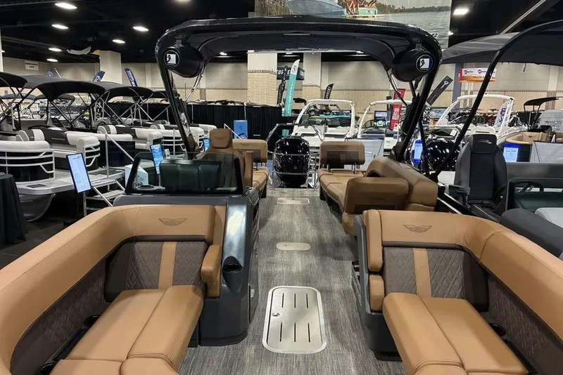 Slide: The Image of 2026 Bennington 23 MSL pontoon boat interior with luxurious seating at a boat show. - 3