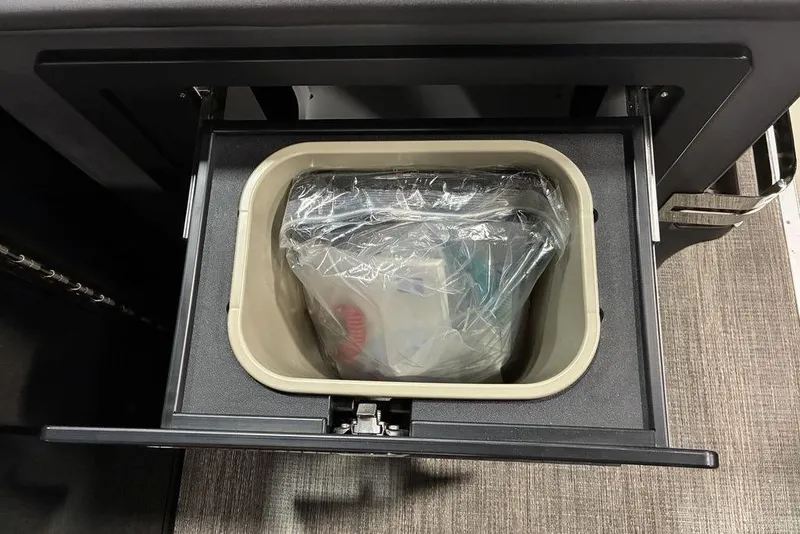 Slide: The Image of Storage compartment in 2026 Bennington 23 MSL boat, featuring a plastic bin with contents. - 5
