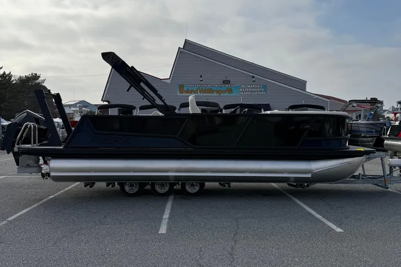 The Image of Alera M23L 2026 pontoon boat parked at a watersports facility. - 1