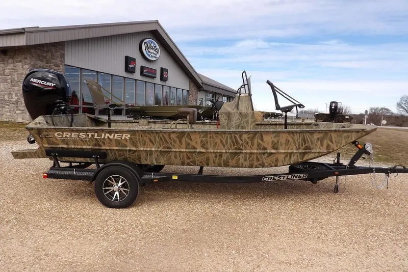 Slide: The Image of 2026 Crestliner 1870 Retriever FCC boat with camouflage design on a trailer outside a dealership. - 3