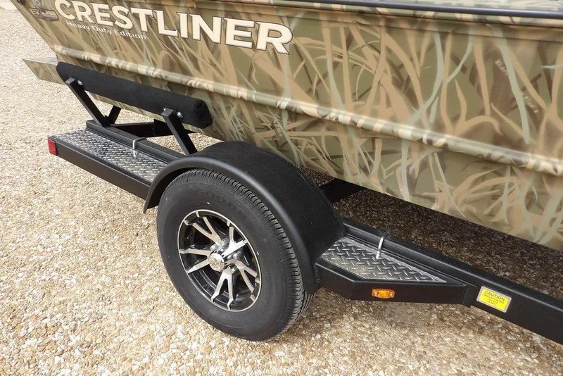 Slide: The Image of 2026 Crestliner 1870 Retriever FCC boat on trailer with camo design and alloy wheels. - 33