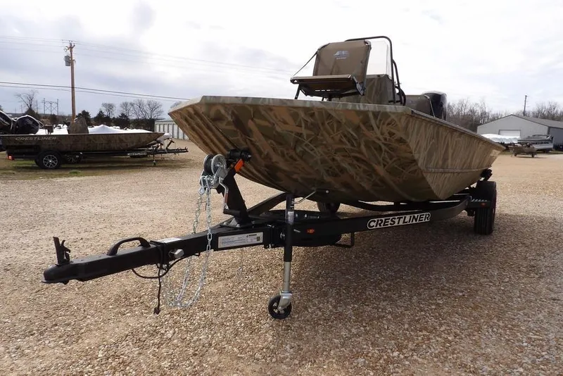 Slide: The Image of 2026 Crestliner 1870 Retriever FCC boat on trailer, camo design, parked outdoors. - 34