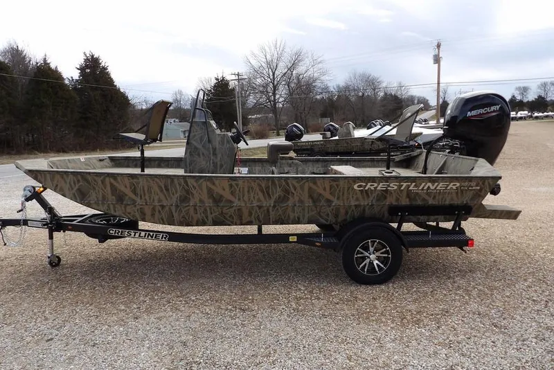 Slide: The Image of 2026 Crestliner 1870 Retriever FCC boat on trailer, camo design, parked outdoors. - 7