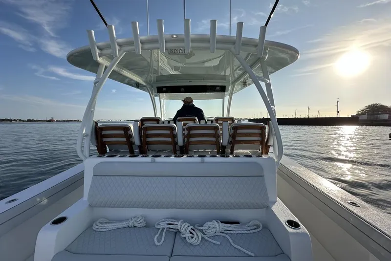 Slide: The Image of 2025 Valhalla Boatworks V-46 on water at sunset, featuring seating and helm. - 11