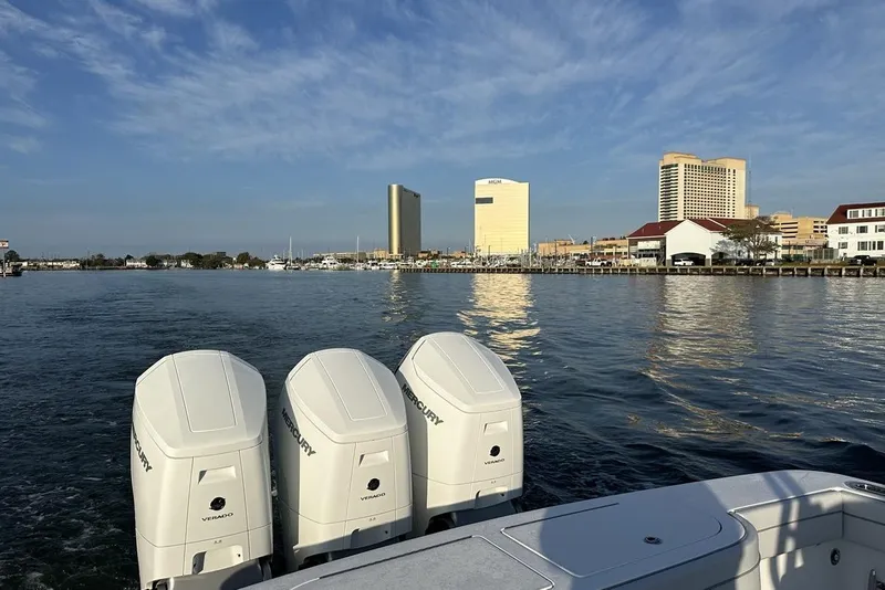 Slide: The Image of 2025 Valhalla Boatworks V-46 with triple Mercury engines on a scenic waterfront. - 15