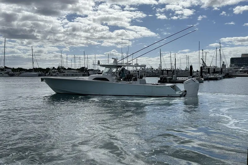 Slide: The Image of 2025 Valhalla Boatworks V-46 in marina, sleek design, calm waters, cloudy sky. - 22