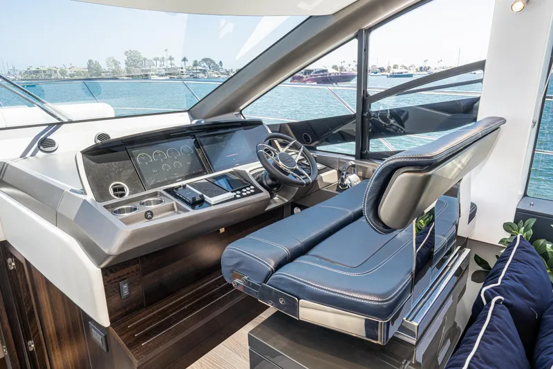 Slide: The Image of 2021 Sunseeker Manhattan 55 yacht helm station with modern controls and luxurious seating. - 17