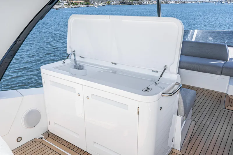 Slide: The Image of Sunseeker Manhattan 55 2021 yacht deck with open storage compartment and ocean view. - 31